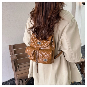 Detail shot of brown quilted PU backpack showing diamond stitching and silver twist locks