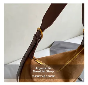 Detail of adjustable leather shoulder strap and gold hardware on brown tote bag