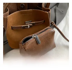 Dettaglio della borsa a secchiello in pelle marrone con chiusura in metallo argento e bustina interna