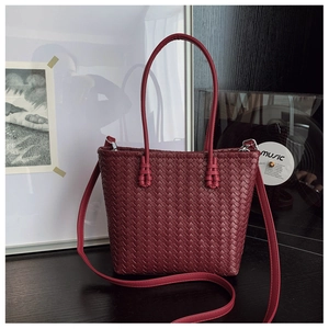 Détail de la texture tressée du sac cabas bordeaux avec poignée et bandoulière