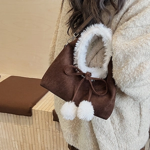 Détail du sac à main en daim marron avec bordure en fausse fourrure et cordon serrage