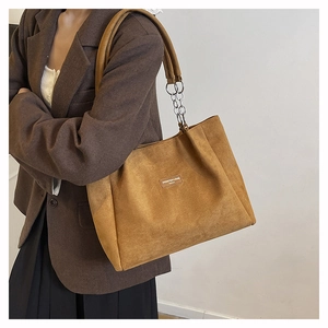 Detail of leopard brown suede tote bag featuring silver chain straps and rectangular patch