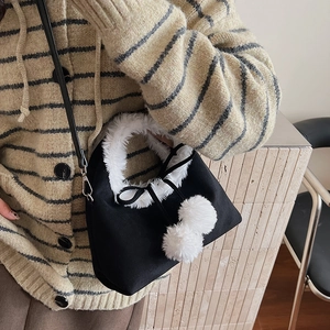 Détail du sac à bandoulière vintage en laine d'agneau avec peluche et pompons déco