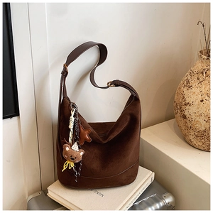Détail du grand sac cabas en daim marron avec pendentif ours et bandoulière large