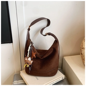 Détail du grand sac cabas en daim marron avec pendentif ours et accessoire en étoile