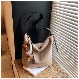 Détail du sac cabas en daim marron avec bandoulière en cuir et charm ours mignon