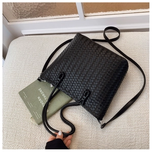 Détail de la texture tressée noire du sac seau avec poignée et fermeture éclair en argent