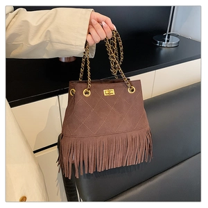 Detail of a brown suede bucket bag featuring quilted stitching and long fringe tassels