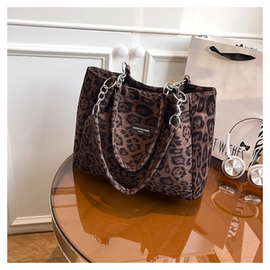 Close-up of leopard print tote bag featuring silver chain straps and luxury velvet texture