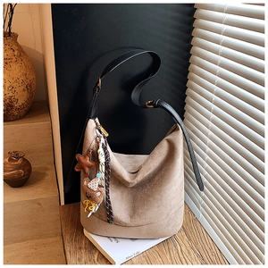 Détail du grand sac cabas en daim marron clair avec des breloques étoile et ourson