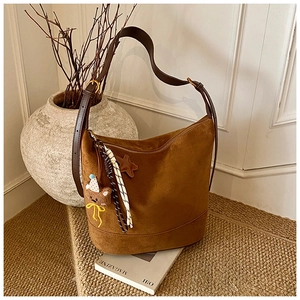 Détail du sac cabas en daim marron foncé avec bandoulière en cuir et grigris peluche
