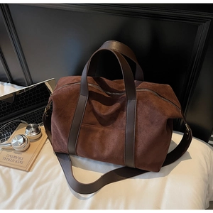 Detailed close-up of dark brown suede tote bag with leather handles and premium stitching