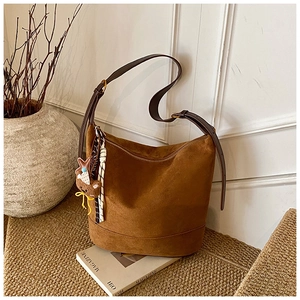 Détail du sac cabas en daim marron avec pendentif ours et foulard à rayures