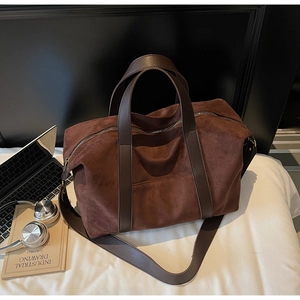 Detail of soft brown suede tote bag with durable handles and spacious interior