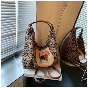 Détail du sac hobo léopard avec un écusson de chat mignon et une bandoulière marron