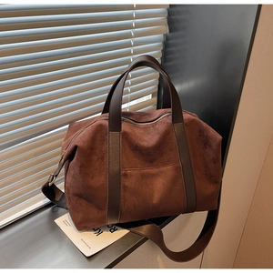 Close-up of the deep brown suede texture and premium leather straps on this tote bag