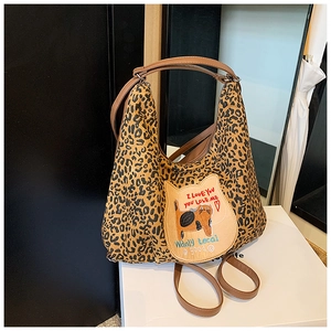 Gros plan du sac cabas léopard avec patch chat unique et anses en cuir