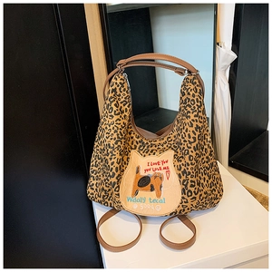 Détail du sac cabas léopard avec patch chat et poignée en cuir marron