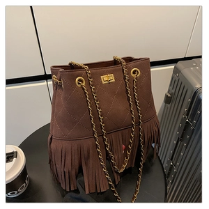 Detail of dark brown suede bucket bag with fringe tassels and gold chain strap