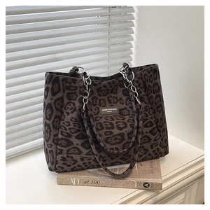 Detail of leopard print tote bag featuring metallic chain straps and soft suede texture
