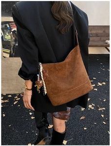 Sac hobo marron foncé en daim avec breloque étoile dans un décor d'automne