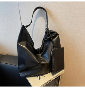 Détail du grand sac cabas noir avec coutures blanches et pochette assortie