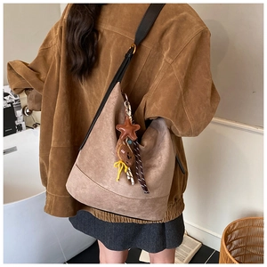 Détail du grand sac cabas en daim marron avec bandoulière et pendentif étoile