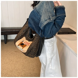 Détail du sac hobo léopard avec écusson chat et motifs brodés sur le devant