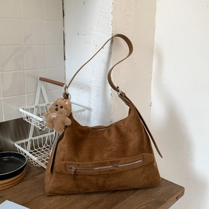 Détail du sac cabas en daim marron avec poche zippée et breloque ours en peluche