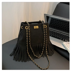 Close-up of black suede fringe bucket bag with quilted patterns and gold metal lock