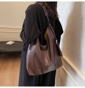 Deep brown tote bag with white contrast stitching and a minimalist hobo silhouette