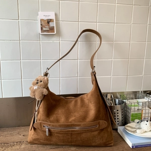 Détail du cabas en daim marron avec poche zippée et charmant petit ours en peluche