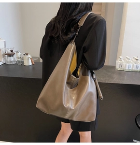Dettaglio della borsa taupe con fodera gialla a contrasto e cuciture decorative