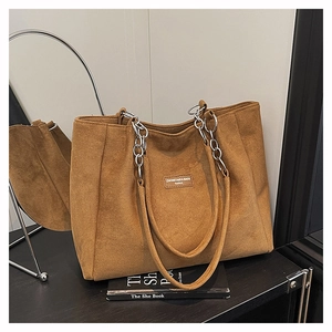 Close-up of leopard print suede tote bag featuring a gold chain strap and brand label