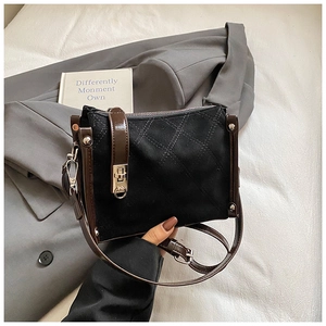 Detailed macro view of quilted suede crossbody bag with silver twist lock and leather strap