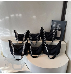 Minimalist black nylon half-moon crossbody bags displayed with diverse woven straps