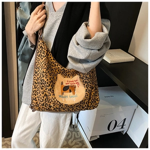 Détail d'un sac cabas léopard avec un écusson chat mignon et une bandoulière en cuir