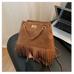 Detail of brown suede fringe bucket bag with quilted patterns and gold metal lock