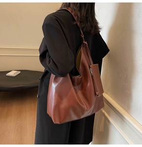 Dettaglio della borsa tote marrone con cuciture bianche a contrasto e una bustina