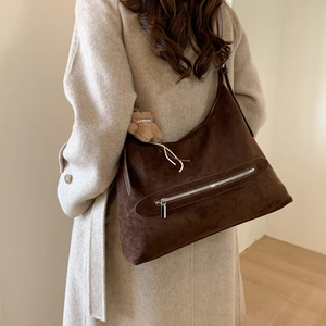 Sac fourre-tout en daim marron avec fermeture éclair et breloque ours sur modèle