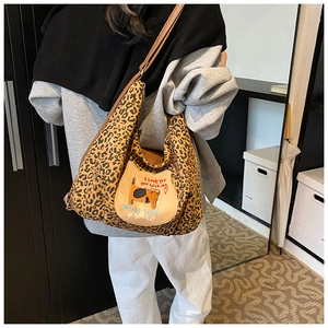 Détail du sac hobo léopard avec écusson de chat unique et bandoulière marron réglable