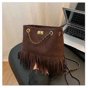 Detailed view of vintage brown tassel bucket bag with gold clasp and chain strap