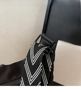 Detail of durable matte black metal buckle and thick black-white V-weave shoulder strap