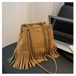 Close-up of brown suede bucket bag with quilted patterns and stylish fringe details