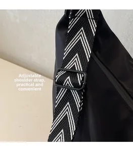 Detail of adjustable black and white herringbone wide strap with matte metal buckle