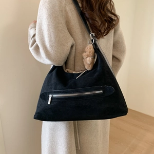 Détail du grand sac cabas noir en daim avec fermeture zippée et pendentif ours