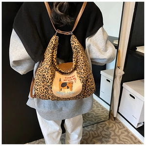 Détail du sac cabas léopard avec écusson de chat brodé et anses en cuir marron