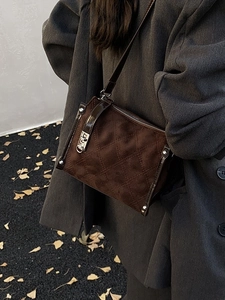 Quilted brown suede crossbody bag with silver lock shown in an autumn street style scene