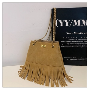 Detail of vintage yellow fringed bucket bag with quilted stitching and chain strap