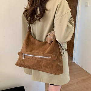 Vue détaillée d'un grand sac cabas en daim marron avec un joli pendentif ours en peluche
